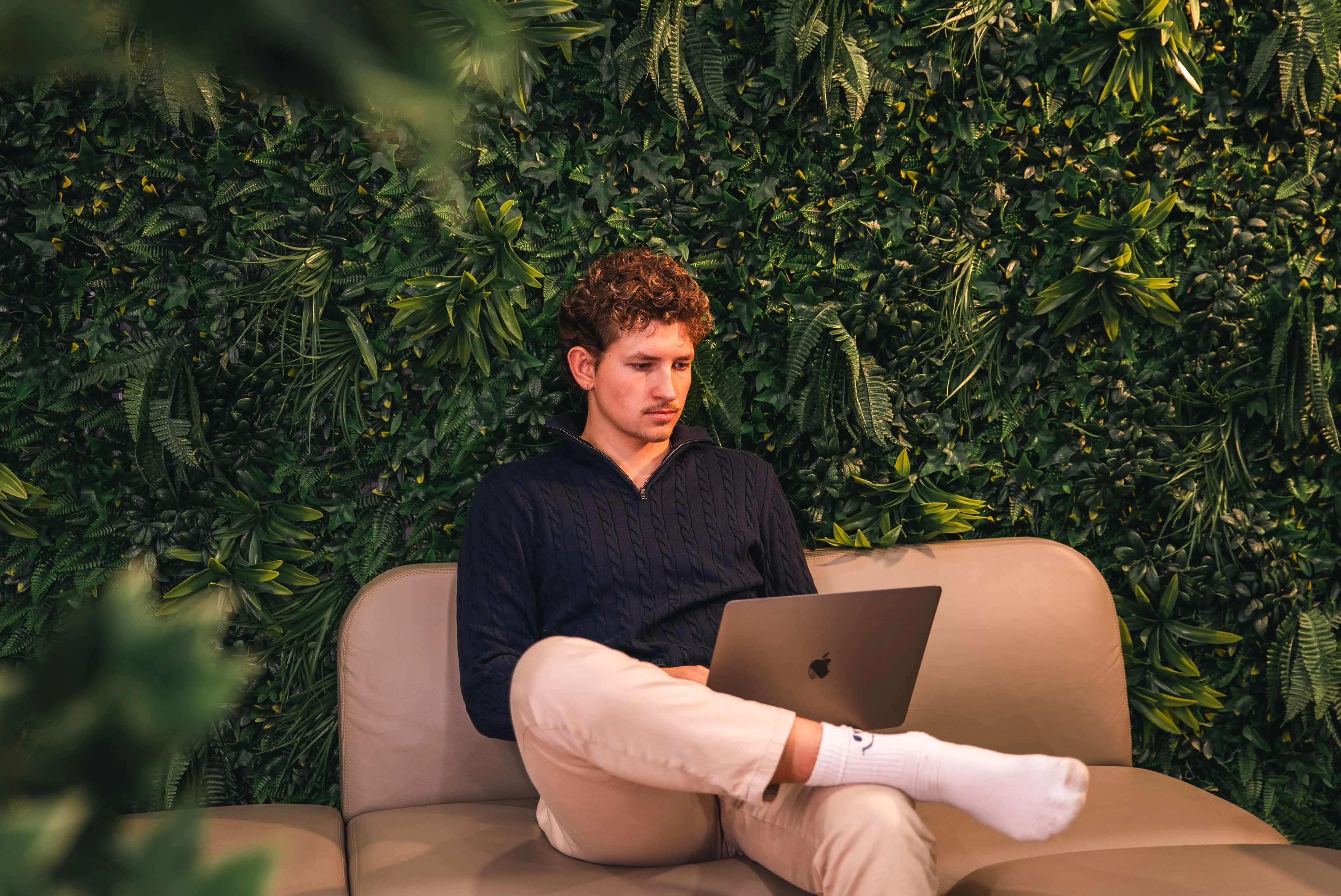A member of the Innovila team working on a laptop on a sofa