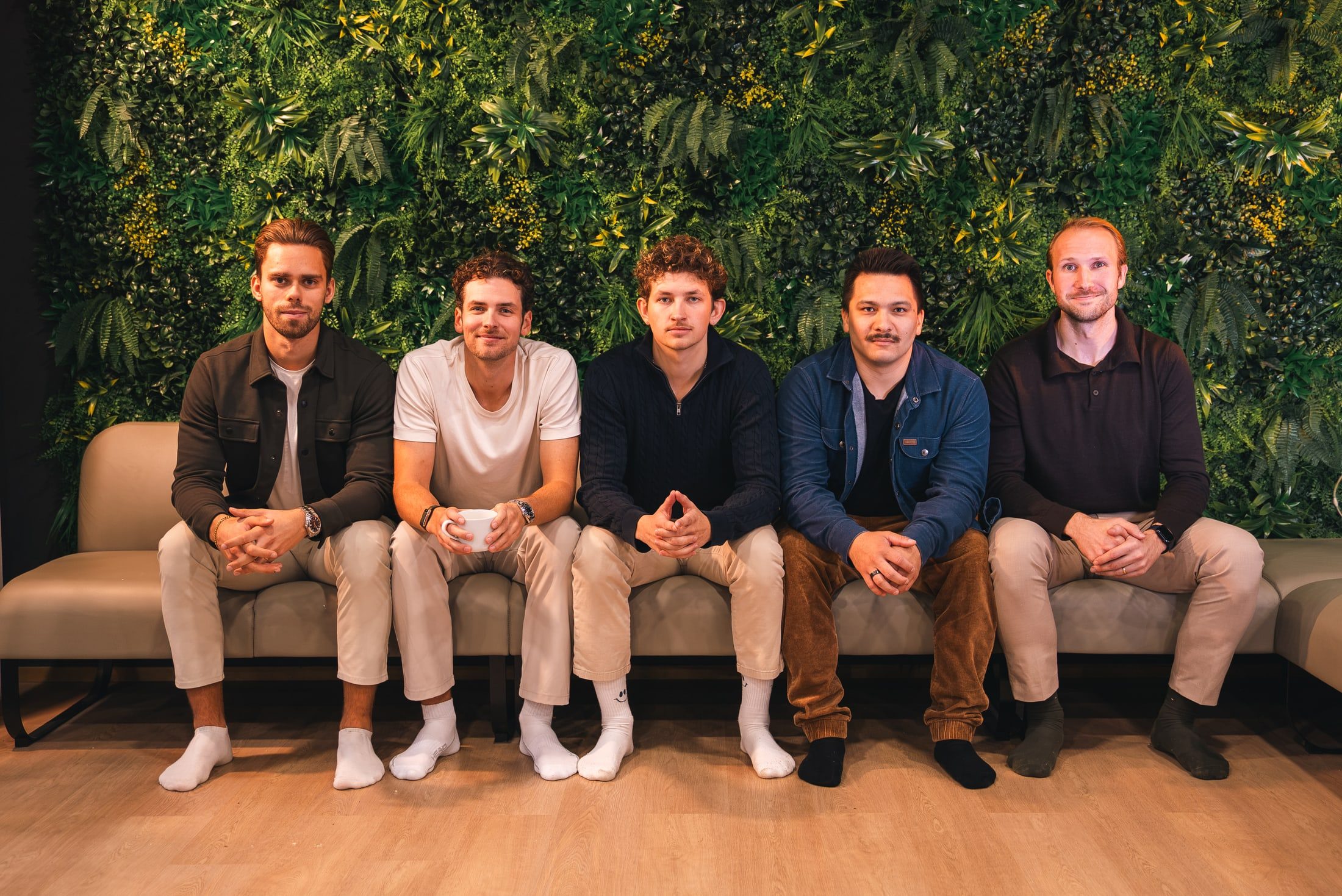 The Innovila team on a sofa in front of a green plant wall. From left: Mikael, Anton, Atte, Eetu and Nikita.