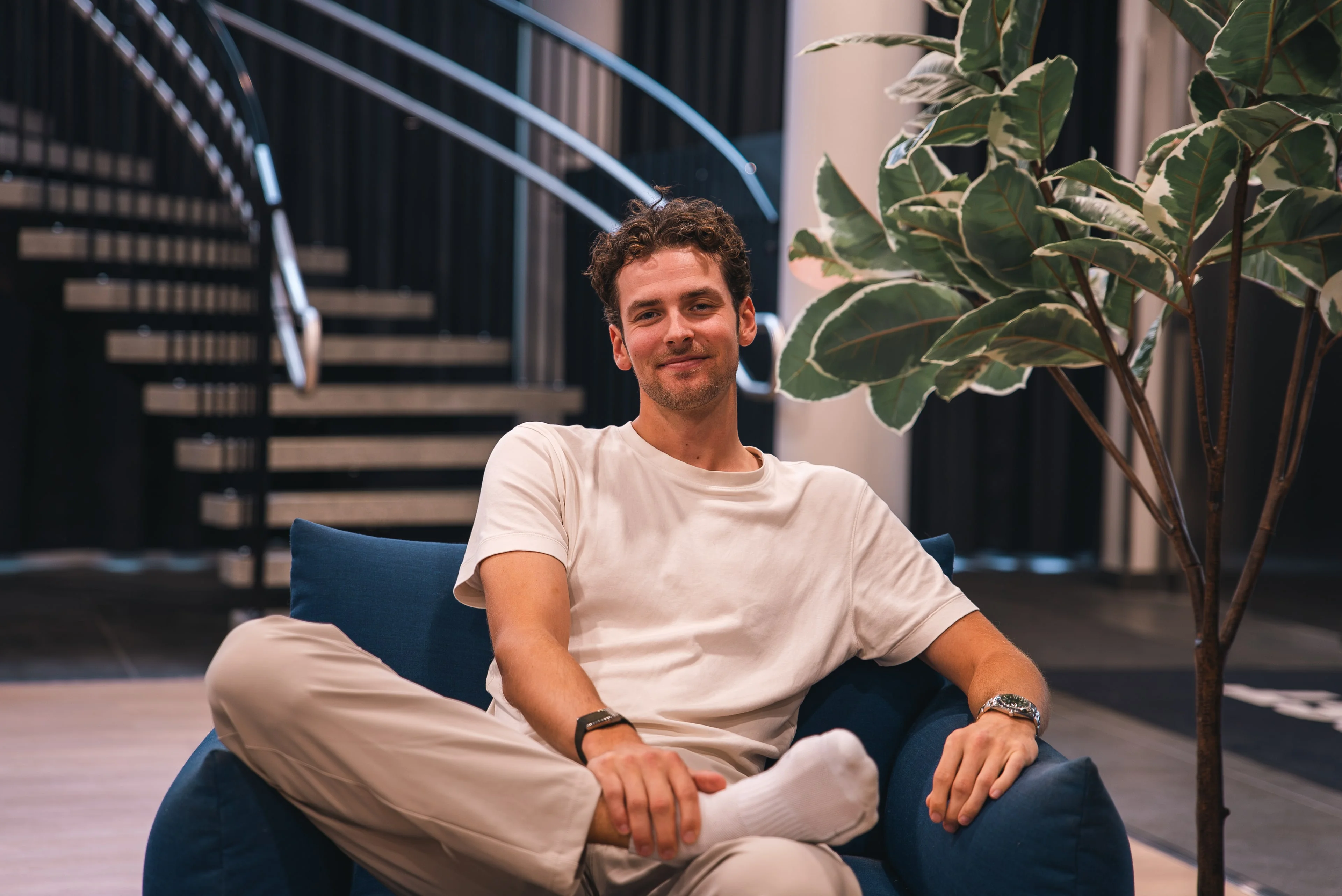 A member of the Innovila team smiling in an armchair in the office lobby