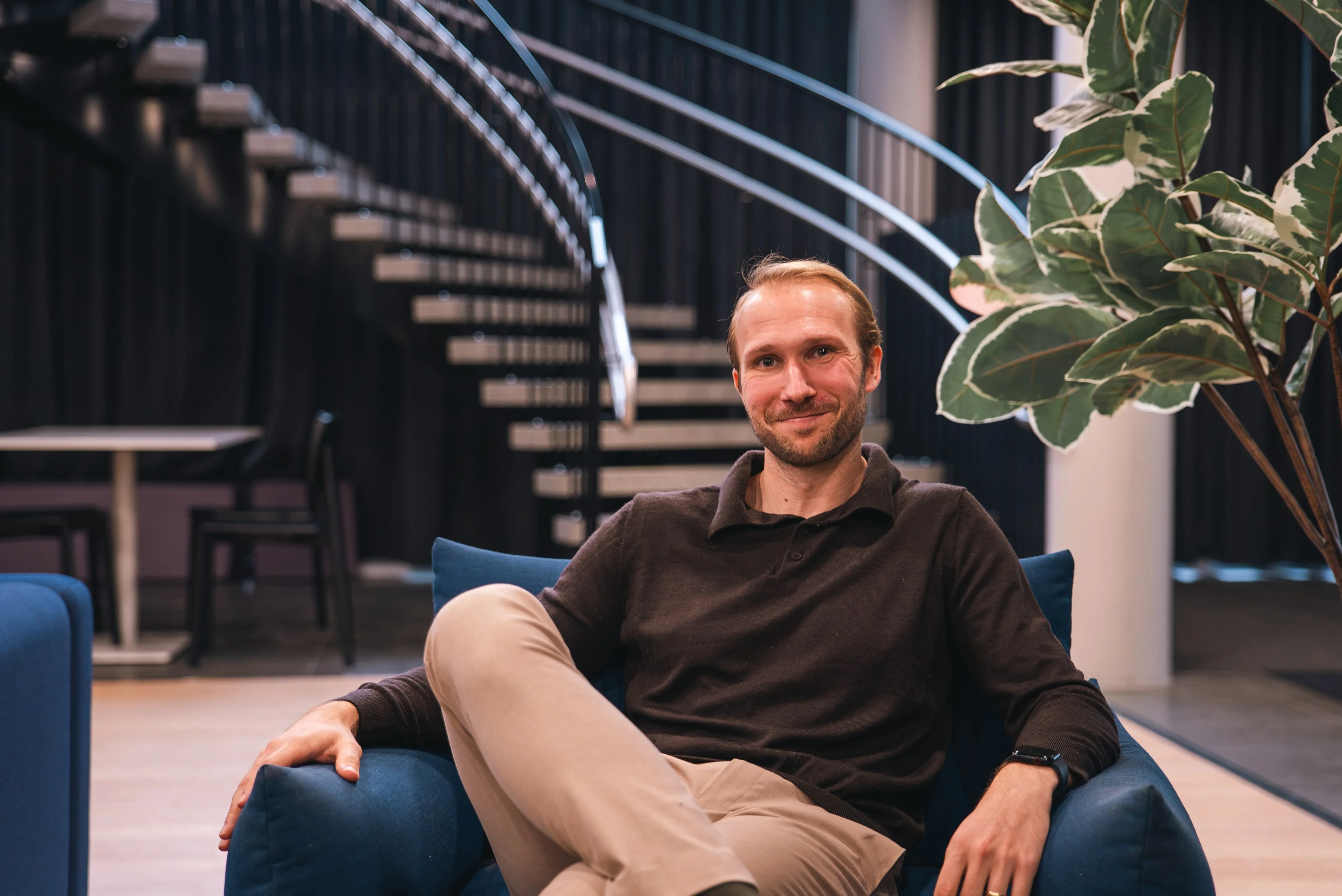 A member of the Innovila team smiling in an armchair in the office lobby