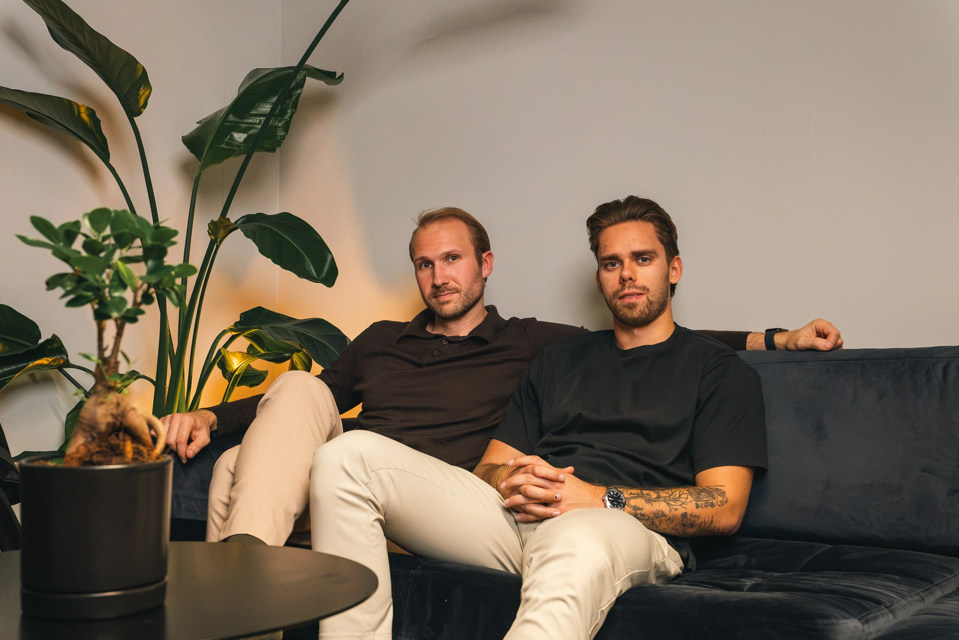 Two members of the Innovila team relaxing on a sofa in the office lounge