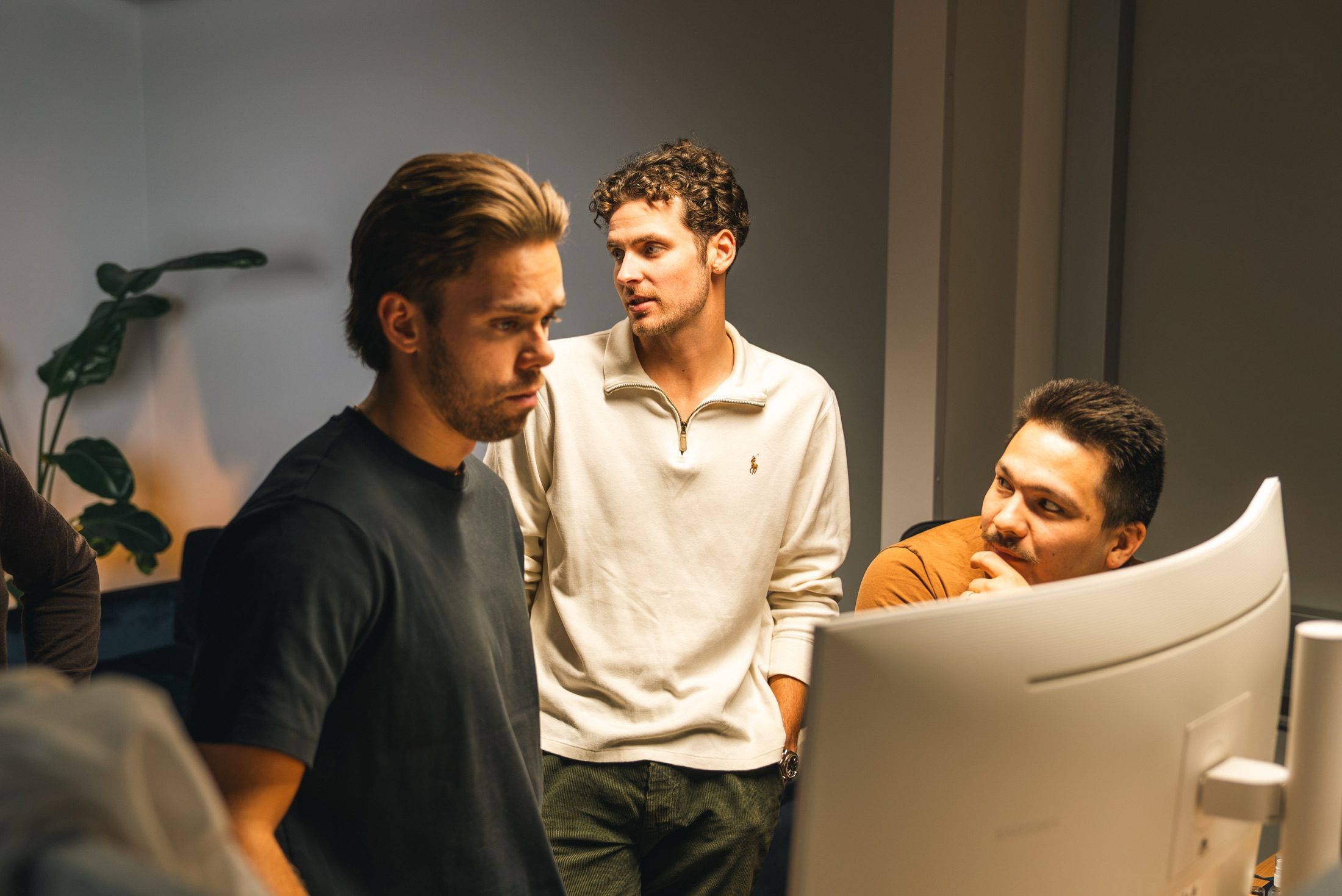 Three members of the Innovila team working together at a computer