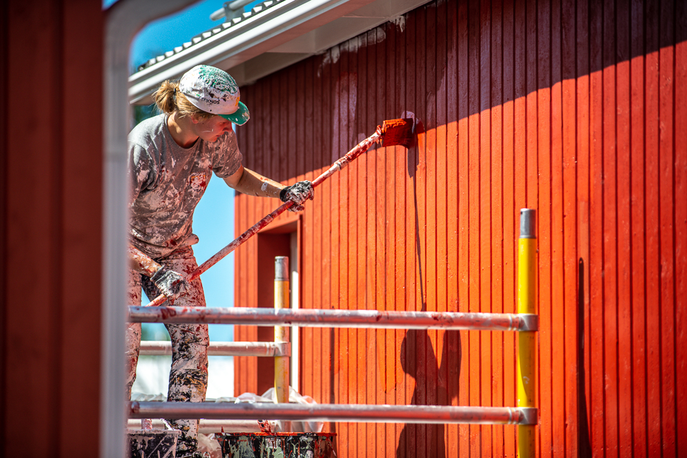 Maalari maalaa taloa